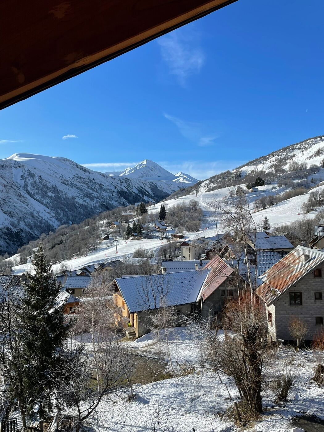 Balcon en bois avec table et chaises, vue sur les montagnes