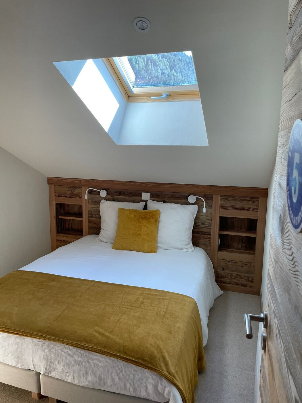 Chambre Les Vallons, couvre-lit jaune moutarde et fenêtre de toit